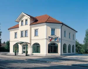Firmengebäude Priller mit Schriftzug an der Fassade und Rundbogenfenstern im Erdgeschoss